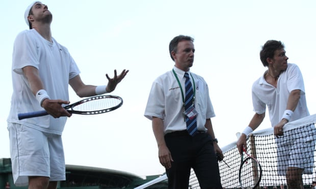 Referee Soeren Friemel, centre, calls off the epic men's singles match between John Isner of the US, left, and Nicolas Mahut of France,because of bad light, at the All England Lawn Tennis Championships at Wimbledon, Wednesday, June 23, 2010. (AP Photo/Alastair Grant)