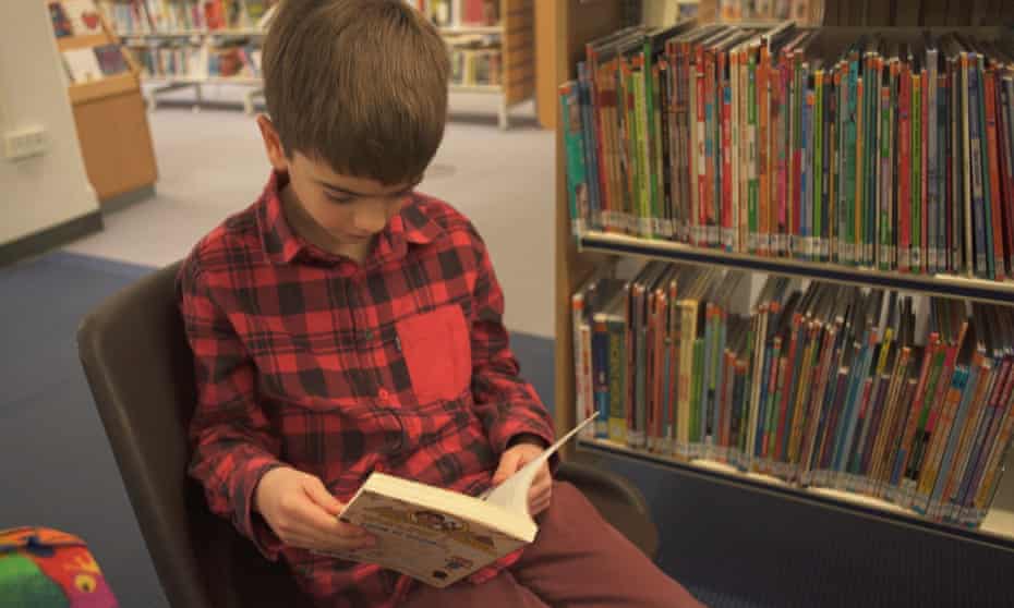 A boy reads a book at Chelmsford library in a promotional video for autism charity Dimensions.