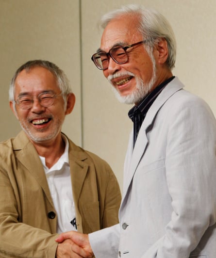 Two Japanese men smile as they shake hands