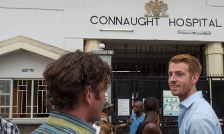 Dr Oliver Johnson, right, talks with a colleague outside the Connaught hospital in Freetown.