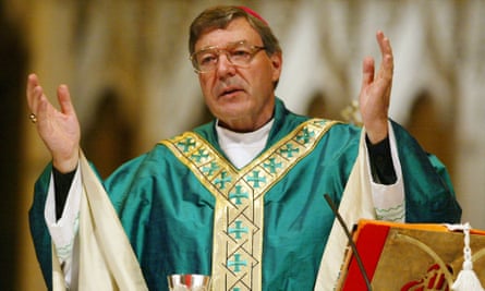 George Pell dressed in with hands raised