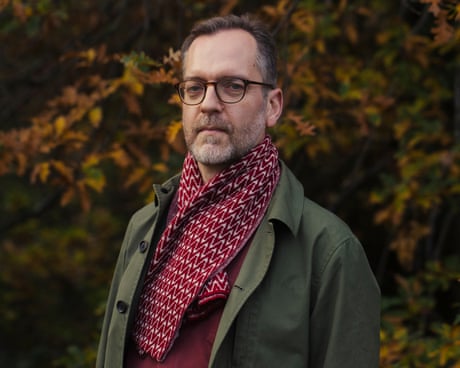 Writer David Batty in green coat and burgundy top and scarf