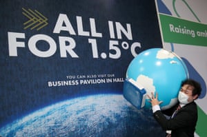 A person carries a globe model at Cop26.