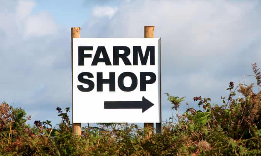 a farm shop sign in a hedge