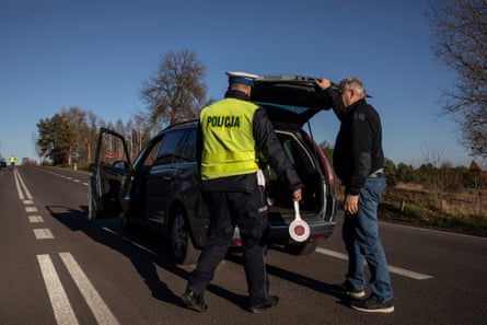 A Polish policeman checks the boot of a car