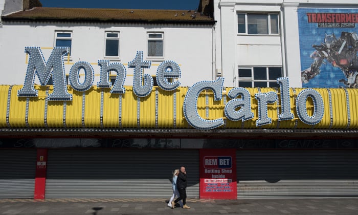 People walk past amusement arcades closed during the lockdown on a very quiet seafront in Southend on Sea.
