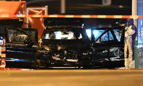 Forensics work on a damaged car with its doors open early on Saturday after the attack in Magdeburg, Germany