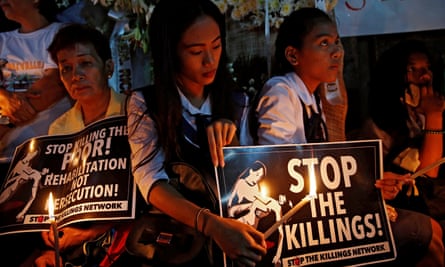 Protesters hold lighted candles at the wake of Kian Loyd delos Santos