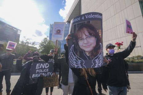 Supporters hold a sign bearing the image of Valentina Orellana-Peralta and others that say "End police brutality" and generally calling for justice for police killings.
