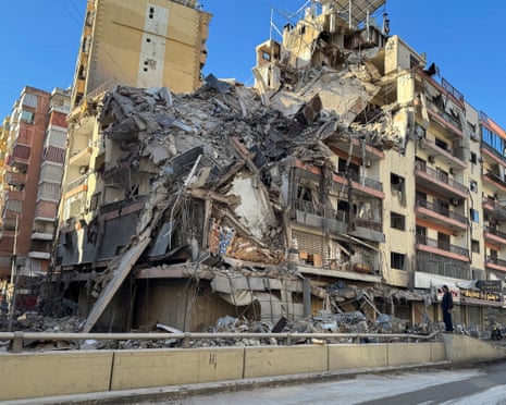 A man stands near a damaged building after Israeli strikes on Beirut’s southern suburbs
