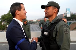 Opposition leader Juan Guaido shakes hands with a soldier near the Generalisimo Francisco de Miranda Airbase in Caracas