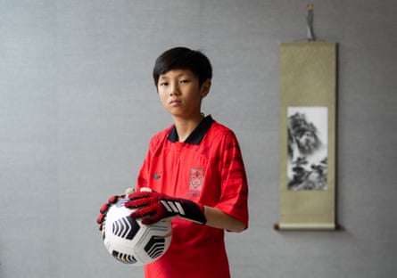 England’s united nations of football: 32 teams, one World Cup – and a lot of excited kids | World Cup 2022 30 Noah Ji-Ha Shin holding a football and wearing goalkeeper’s gloves and a red South Korea shirt