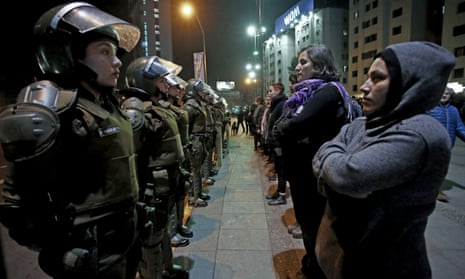 A group of women face a line of policewomen in anti-riot gear before a march protesting sexual harassment in Santiago, Chile, on 1 June.