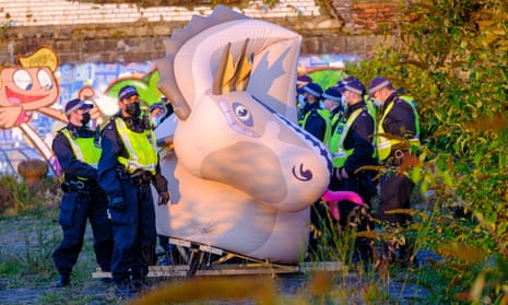 Police officers guarding an inflatable Loch Ness monster at Govan Dry Dock after it was seized in a dawn raid during the Cop26 summit in Glasgow.