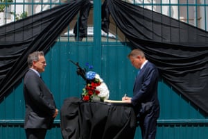 Bucharest, Romania President Klaus Iohannis (R) signs a condolence book as French ambassador Francois Saint-Paul looks on
