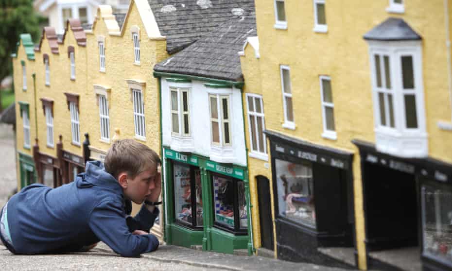 A boy looks like a giant as he looks through a shop window during a visit to The Model Village in Godshill on the Isle of Wight