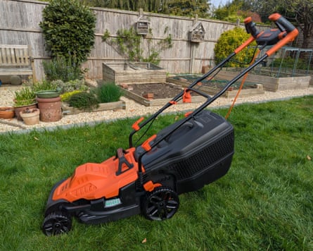 A Black+Decker lawnmower in a garden.