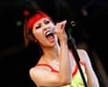 Singer Saffron of Republica sings passionately into a microphone on stage