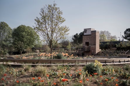 A brick tower overlooking a formal garden.