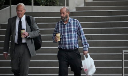 Man carrying bag on steps of courthouse with lawyer