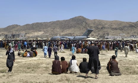 Hundreds of people gather near a US Air Force C-17 transport plane at the perimeter of the international airport in Kabul, Afghanistan, on 16 August 2021. 