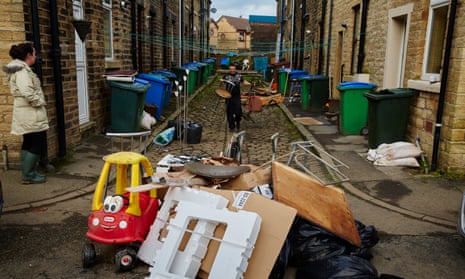 Residents in Littleborough, where 180 households have been flooded out, clear up their homes