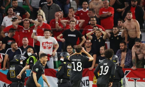 Germany’s Leon Goretzka celebrates in front of dejected Hungary fans.