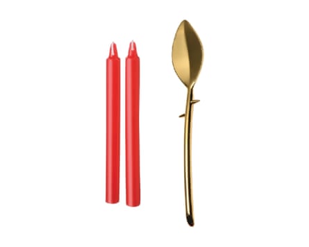 Drip Sensation Spoon and Wax Play Candle Set. Two red candles next to a large, gold, leaf-shaped spoon.