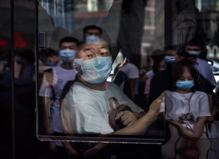 A commuter wears a mask to protect against Covid-19 as he sits on a bus on 4 August 2021 in Beijing.