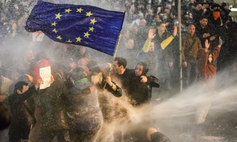 Protesters brandishing an EU flag are hit by a water cannon during clashes with riot police near the Georgian parliament in Tbilisi last week.
