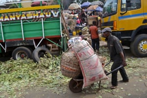 A man pushes a cart filled with baskets of tomatoes at a local market in Enugu.