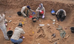 In this photo taken 18 February 2014, members of the Peruvian Forensic Anthropology Team work to uncover bodies buried in a mass grave in Hargeisa, Somaliland, a breakaway region of Somalia.