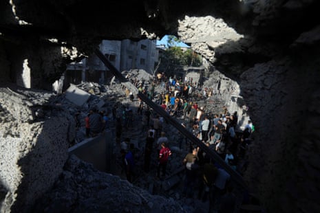 Palestinians look for survivors after Israeli airstrikes on buildings in Deir al Balah.