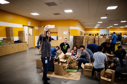 PayPal employees pose for a picture of themselves volunteering to sort produce at Second Harvest Food Bank in San Jose, California.