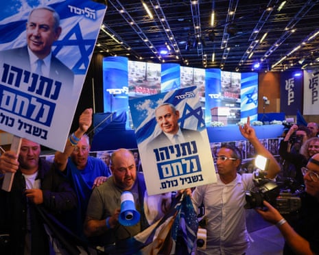 oamenii țin pancarte cu chipul lui Netanyahu pe ele