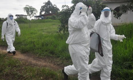Health workers carry out tests in an area where a 17-year-old boy died from Ebola, on the outskirts of Monrovia, Liberia, on 30 June 2015. 