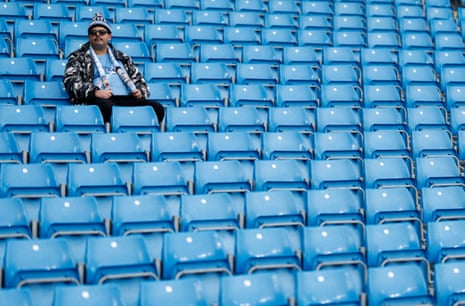 A Manchester City fan sits alone in the stands long before kick-off.