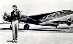 A woman stands in front of a plane