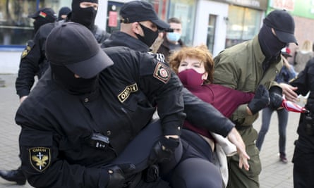Police officers detain a woman during an opposition rally