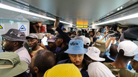 Passengers crammed in to a busy commuter train