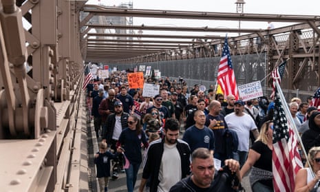 people march across the brooklyn bridge with american flags