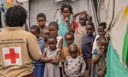 A Red Cross worker and a group of children