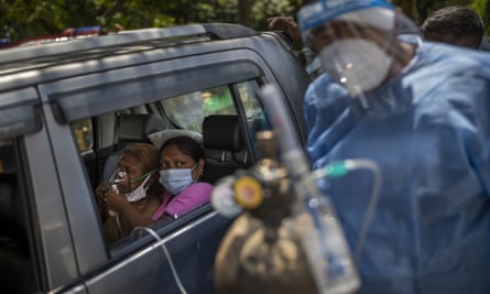 A patient receives oxygen inside a car in New Delhi, where the oxygen shortage has become dire.