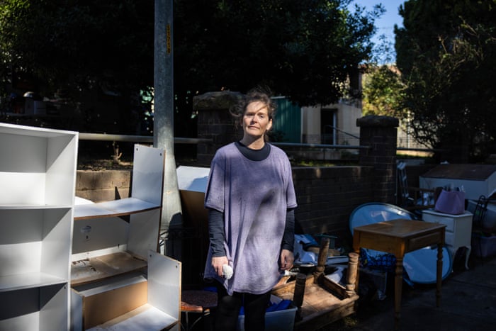 Melanie Woods stands in front of her Windsor home after tossing flood-damaged belongings onto the street. Flood recovery efforts have begun in the town following record-level flooding along the Hawkesbury River in NSW.