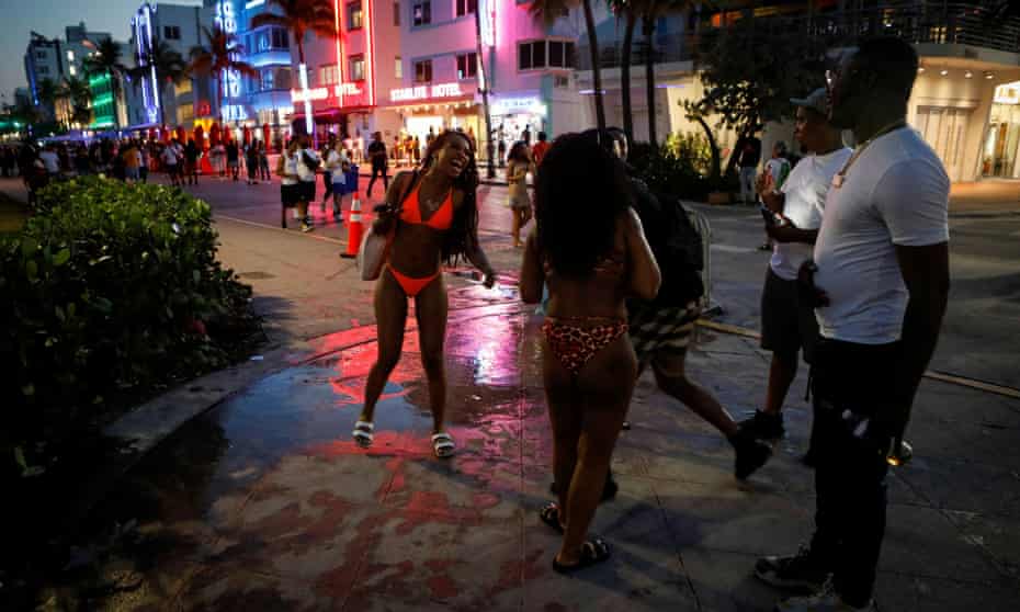 People enjoy spring break festivities ahead of an 8pm curfew imposed by local authorities in Miami Beach this week.