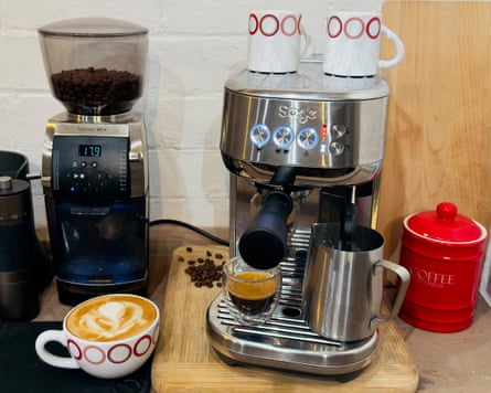 Image 2: A sideboard with a silver coffee machine, black coffee grinder, a cup of coffee and a bag of coffee beans