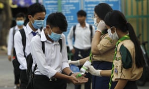 Students disinfect their hands to avoid the contact of coronavirus before their morning class at Santhormok high school, in Phnom Penh, Cambodia today.