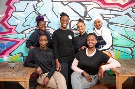 Six women sitting and standing at restaurant tables