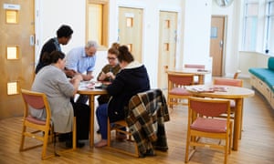 Staff helping a service user (right) during a crafts session at Guild Lodge.