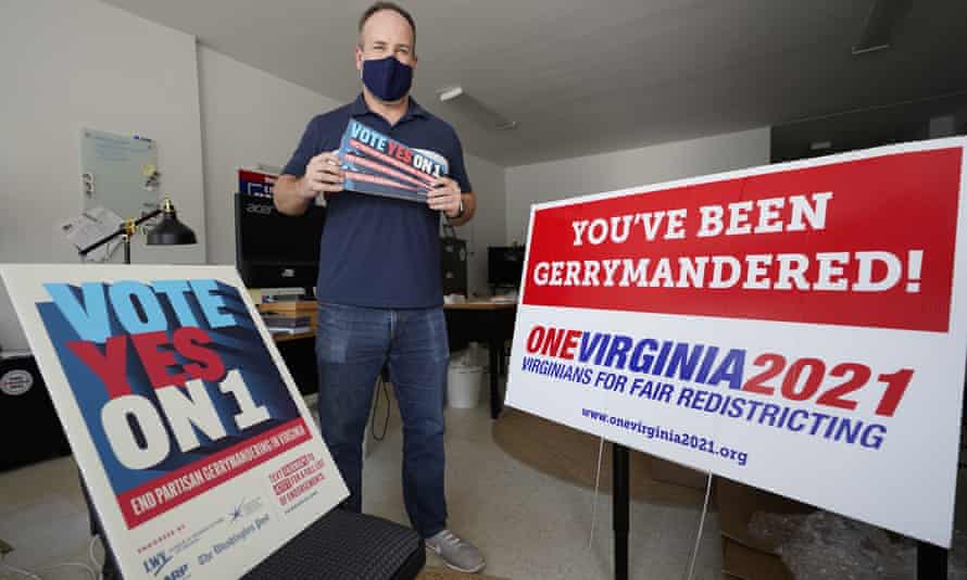 Redistricting reform advocate Brian Cannon poses with some of his yard signs and bumper stickers in his office in Richmond, Virginia, in October 2020.